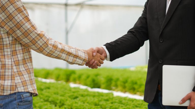 Agribusiness,Concept,,Farmer,And,Businessman,Shaking,Hand,With,Hydroponic,Farm